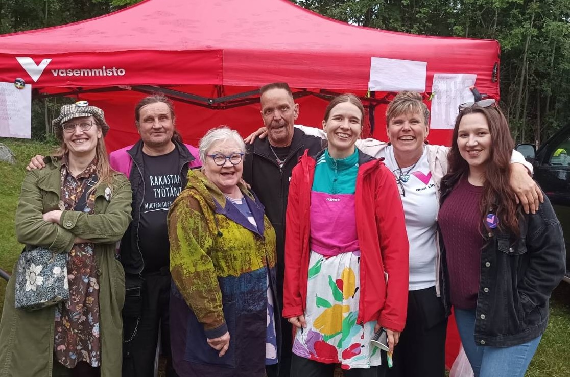 Local members of the left alliance standing in front of an event stand.